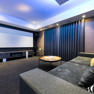 Example of a trendy enclosed carpeted and gray floor home theater design in Perth with multicolored walls and a projector screen