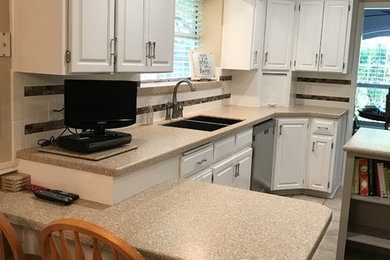This is an example of a mid-sized transitional l-shaped separate kitchen in Austin with a double-bowl sink, raised-panel cabinets, white cabinets, solid surface benchtops, multi-coloured splashback, mosaic tile splashback, stainless steel appliances, porcelain floors, with island and beige floor.