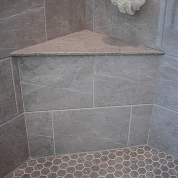 Waypoint Gray Shaker Door Cabinetry with Tiled Shower and Matching Tub Surround