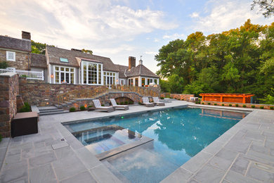 Inspiration for a large country backyard rectangular natural pool in New York with a hot tub and concrete slab.