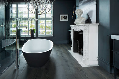 Photo of a traditional bathroom in London with a freestanding tub, blue walls and dark hardwood floors.