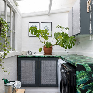 Bohemian l-shaped separated utility room in London with shaker cabinets, white walls, a side by side washer and dryer and multicoloured worktops.