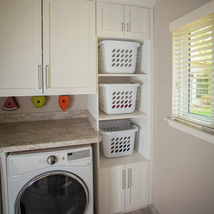 Small contemporary galley separated utility room in Detroit with a belfast sink, white cabinets, granite worktops, beige walls, a side by side washer and dryer, beige floors, ceramic flooring and shaker cabinets.