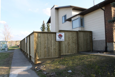 Photo of a mid-sized partial sun side yard concrete paver retaining wall landscape in Calgary for summer.