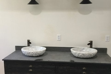 サンディエゴにある中くらいなトランジショナルスタイルのおしゃれなマスターバスルーム (家具調キャビネット、濃色木目調キャビネット、白い壁、セメントタイルの床、ベッセル式洗面器、御影石の洗面台、グレーの床、グレーの洗面カウンター) の写真