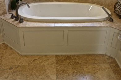 Country master bathroom in New Orleans with a corner tub, beige tile, ceramic tile and ceramic floors.