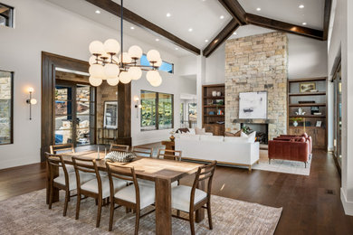 Huge mountain style dark wood floor, brown floor and exposed beam great room photo in Salt Lake City with a stone fireplace