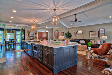 Open concept kitchen - huge transitional single-wall medium tone wood floor open concept kitchen idea in Other with an undermount sink, shaker cabinets, black cabinets, granite countertops, beige backsplash, subway tile backsplash, stainless steel appliances, an island and beige countertops