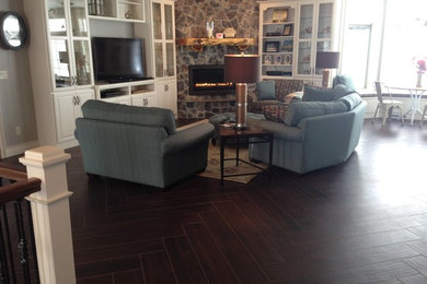 Example of a mid-sized arts and crafts open concept porcelain tile and gray floor family room design in Other with gray walls, a ribbon fireplace, a stone fireplace and no tv