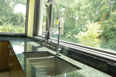 Large minimalist u-shaped porcelain tile eat-in kitchen photo in Baltimore with flat-panel cabinets, light wood cabinets, an island and a double-bowl sink