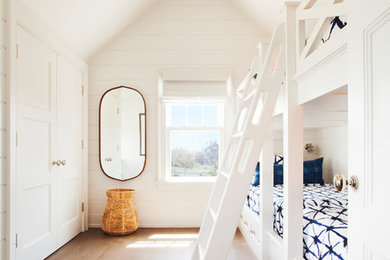 Beach style gender-neutral dark wood floor and brown floor kids' bedroom photo in Other with white walls