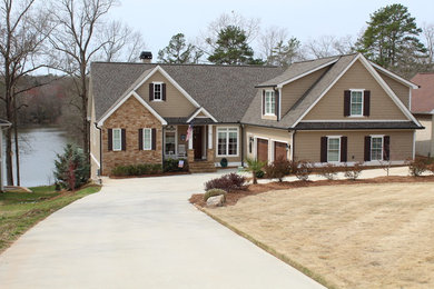 Large arts and crafts brown two-story mixed siding house exterior photo in Other with a shingle roof