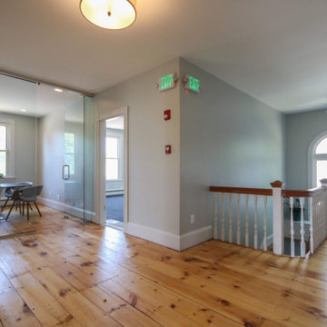 Small conference room with glass wall, refinished wood floors