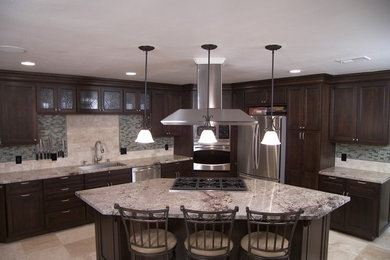 Open concept kitchen - traditional l-shaped open concept kitchen idea in Orange County with an undermount sink, recessed-panel cabinets, dark wood cabinets, granite countertops, green backsplash and stainless steel appliances