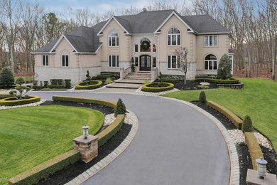Mid-sized traditional beige two-story stucco house exterior idea in New York with a hip roof and a shingle roof