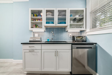 Enclosed kitchen - small transitional galley vinyl floor enclosed kitchen idea in Columbus with shaker cabinets, white cabinets, quartz countertops, blue backsplash, glass tile backsplash and black countertops