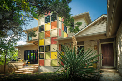 Example of a mid-sized 1960s green two-story concrete fiberboard exterior home design in Austin with a shingle roof and a brown roof