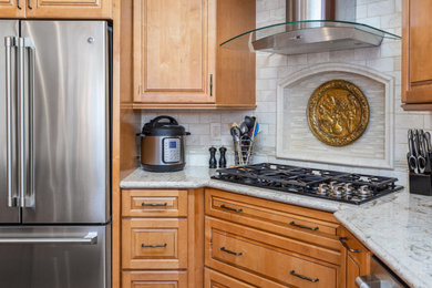 Transitional kitchen photo in San Francisco with medium tone wood cabinets, beige backsplash and stainless steel appliances