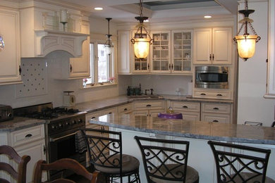 Example of a large classic u-shaped dark wood floor eat-in kitchen design in New York with an undermount sink, raised-panel cabinets, white cabinets, quartzite countertops, white backsplash, subway tile backsplash, stainless steel appliances and a peninsula