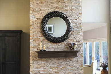 Example of a large classic open concept medium tone wood floor and brown floor living room design with a stone fireplace, beige walls and no tv