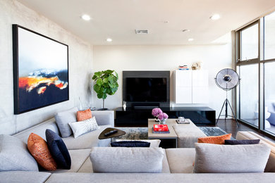 Photo of a mid-sized contemporary living room in Las Vegas with white walls, dark hardwood floors, brown floor and a wall-mounted tv.