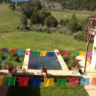 Geräumiger Stilmix Garten im Sommer, hinter dem Haus mit Auffahrt, direkter Sonneneinstrahlung und Natursteinplatten in Denver