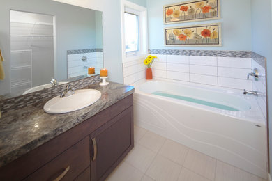 Example of a mid-sized classic porcelain tile porcelain tile bathroom design in Calgary with dark wood cabinets, laminate countertops and blue walls