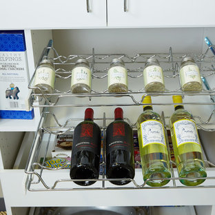 Klassisk inredning av ett mellanstort skafferi, med släta luckor, vita skåp, vitt stänkskydd och heltäckningsmatta