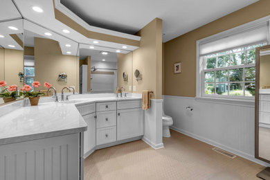Inspiration for a large timeless master ceramic tile, beige floor and double-sink bathroom remodel in New York with shaker cabinets, white cabinets, a one-piece toilet, beige walls, an undermount sink, quartz countertops, beige countertops and a built-in vanity