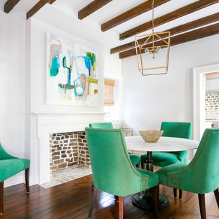 Geschlossenes, Kleines Modernes Esszimmer mit weißer Wandfarbe, braunem Holzboden, Kamin, Kaminsims aus Holz und braunem Boden in Charleston