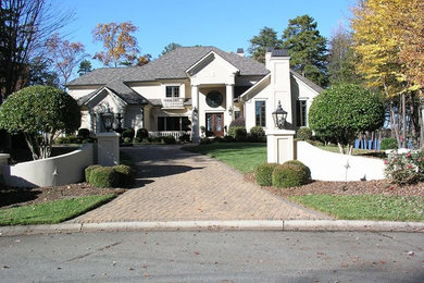 Large beige stucco exterior home idea in Charlotte with a hip roof