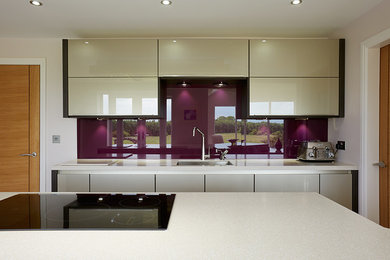 Design ideas for a large contemporary l-shaped kitchen/diner in Other with a submerged sink, flat-panel cabinets, beige cabinets, engineered stone countertops, glass sheet splashback, stainless steel appliances, light hardwood flooring and an island.