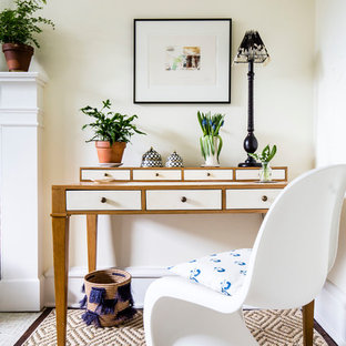 Ejemplo de despacho tradicional renovado, de tamaño medio, con paredes amarillas, moqueta, chimenea tradicional, marco de chimenea de ladrillo, escritorio independiente y suelo beige