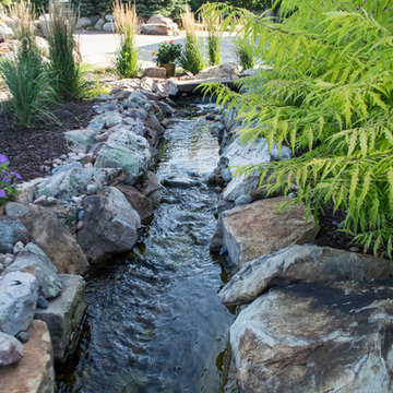 Rustic Mountain stream flowing into lakeside patio