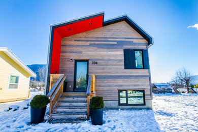 Small mountain style brown two-story wood house exterior photo in Vancouver with a shed roof and a metal roof