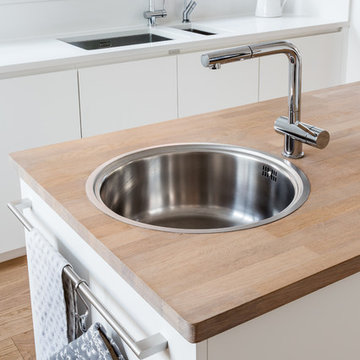 Sleek Scandinavian kitchen in white with separate pantry