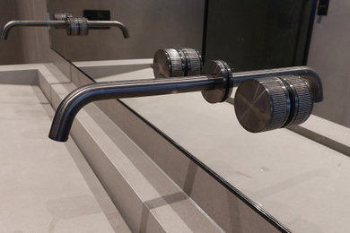 Inspiration for a medium sized modern ensuite bathroom in Hertfordshire with beaded cabinets, black cabinets, a freestanding bath, a walk-in shower, a wall mounted toilet, beige tiles, porcelain tiles, beige walls, porcelain flooring, an integrated sink, engineered stone worktops, beige floors, an open shower, beige worktops, double sinks and a floating vanity unit.