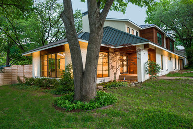 Transitional white two-story house exterior idea in Dallas with a hip roof and a metal roof