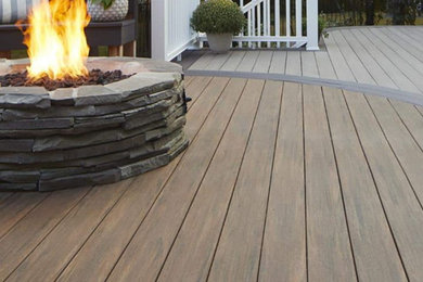 Example of a large minimalist backyard ground level wood railing deck design in DC Metro with a bbq area and no cover