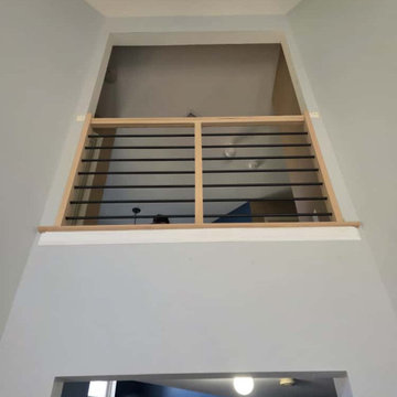 Modern Horizontal Stair Railing with Black Metal Bars and Red Oak T-Rail