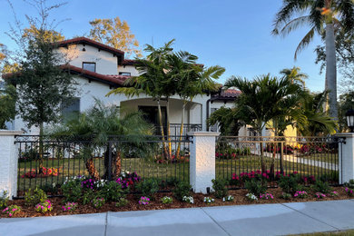 Inspiration for a mid-sized mediterranean white two-story stucco exterior home remodel in Tampa with a tile roof and a red roof