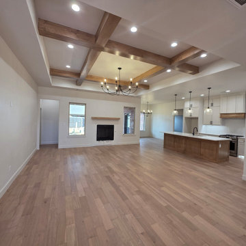 Open concept with beamed ceilings, hardwood floors, and recessed lighting