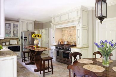 Photo of a mid-sized traditional u-shaped eat-in kitchen in Birmingham with an undermount sink, raised-panel cabinets, white cabinets, granite benchtops, beige splashback, stone tile splashback, stainless steel appliances and with island.