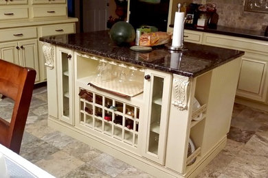 Inspiration for a mid-sized timeless l-shaped eat-in kitchen remodel in Other with a double-bowl sink, raised-panel cabinets, beige cabinets, granite countertops, gray backsplash, stone tile backsplash, black appliances and an island