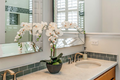 Mid-sized cottage master blue tile and subway tile porcelain tile tub/shower combo photo in Chicago with an undermount sink, quartz countertops, a two-piece toilet, white walls, raised-panel cabinets and medium tone wood cabinets