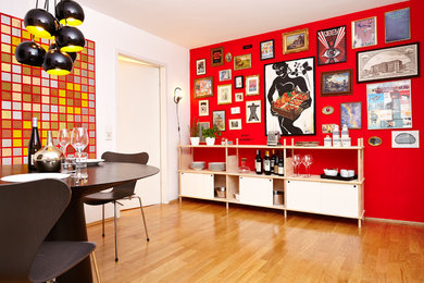 Mittelgroße Moderne Wohnküche mit roter Wandfarbe und braunem Holzboden in Frankfurt am Main