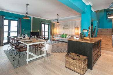パリにあるお手頃価格の中くらいな北欧スタイルのおしゃれなオープンリビング (青い壁、淡色無垢フローリング、コーナー設置型暖炉、漆喰の暖炉まわり、ベージュの床) の写真