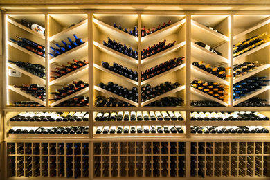 Photo of a large transitional wine cellar in New York with porcelain floors, display racks and brown floor.