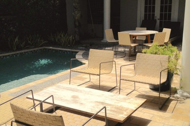 Design ideas for a small transitional courtyard rectangular pool in Miami with natural stone pavers.