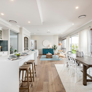 Photo of a beach style open plan dining in Perth with beige walls, medium hardwood floors and brown floor.